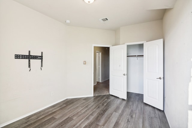 unfurnished bedroom with a closet and dark hardwood / wood-style flooring