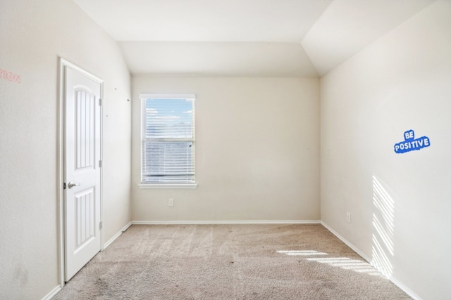 carpeted empty room featuring lofted ceiling