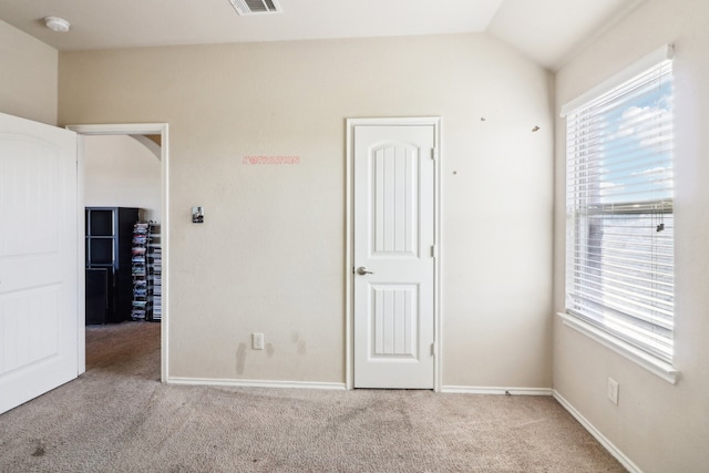 carpeted spare room with lofted ceiling