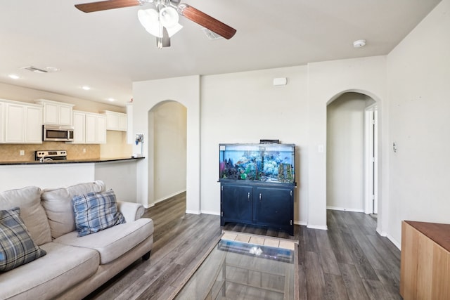 living room with ceiling fan and dark hardwood / wood-style floors