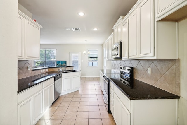 kitchen with sink, stainless steel appliances, decorative backsplash, and light tile patterned flooring