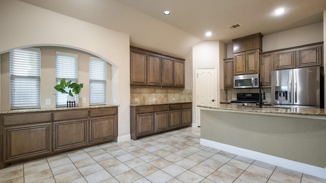 3123 Pamplona, Grand Prairie, TX 75054 - kitchen featuring appliances with stainless steel finishes, backsplash, light stone countertops, a sink, and light tile patterned flooring