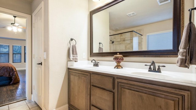 3123 Pamplona, Grand Prairie, TX 75054 - ensuite bathroom featuring ceiling fan, double vanity, tiled shower, tile patterned floors, and baseboards