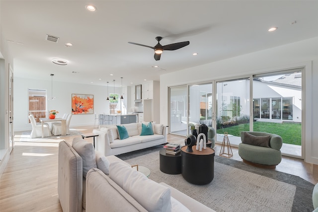 living room featuring light hardwood / wood-style flooring and ceiling fan