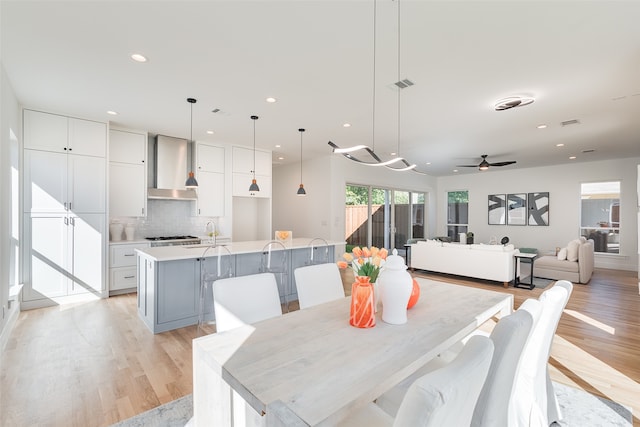 dining space featuring light hardwood / wood-style flooring, sink, and ceiling fan