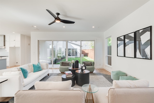 living room with light hardwood / wood-style flooring and ceiling fan