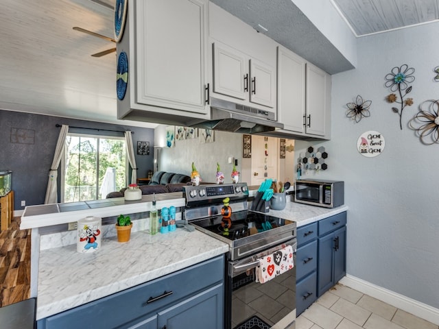 kitchen with blue cabinets, appliances with stainless steel finishes, and white cabinetry