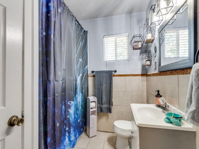 bathroom with a wealth of natural light, vanity, toilet, and tile patterned flooring