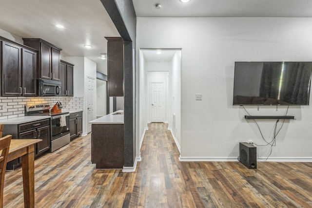 kitchen with dark brown cabinetry, backsplash, stainless steel electric range, and dark hardwood / wood-style flooring