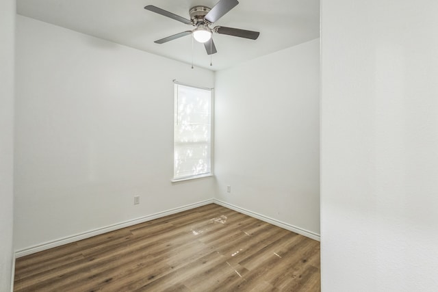 empty room with ceiling fan and dark hardwood / wood-style flooring