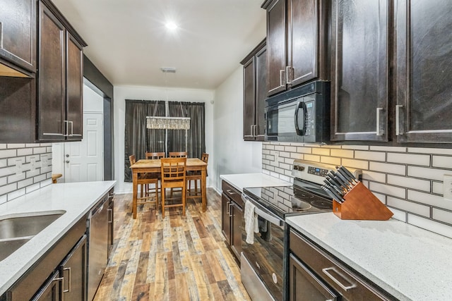 kitchen with light hardwood / wood-style floors, tasteful backsplash, stainless steel appliances, and dark brown cabinets