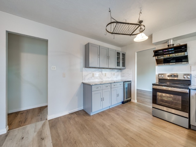 kitchen featuring light stone countertops, beverage cooler, light wood-type flooring, and electric stove