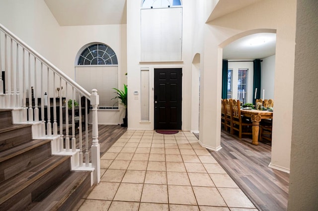 entrance foyer with a towering ceiling and light wood-type flooring