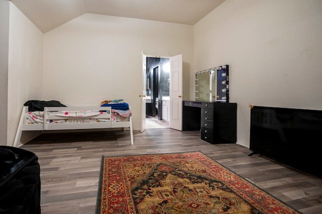 bedroom featuring dark wood-type flooring and vaulted ceiling