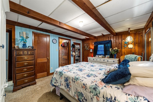 bedroom featuring beamed ceiling, wooden walls, and light colored carpet