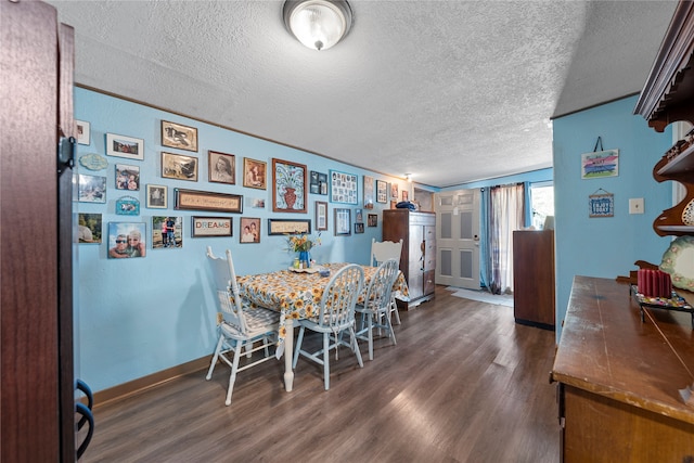 dining room with a textured ceiling and dark hardwood / wood-style floors