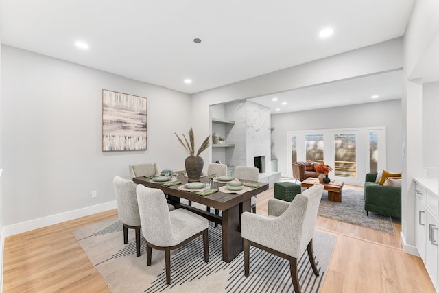 dining area with a fireplace and light hardwood / wood-style floors