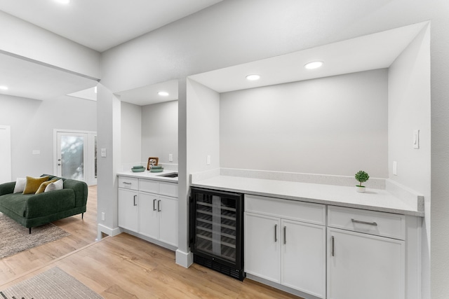 bar featuring white cabinetry, wine cooler, and light wood-type flooring