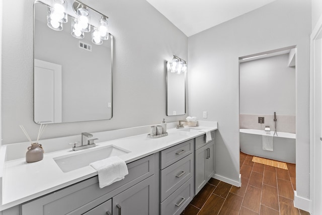 bathroom with vanity and a washtub