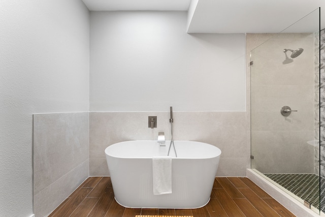 bathroom with tile walls and plus walk in shower