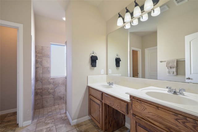 bathroom with vanity and tiled shower