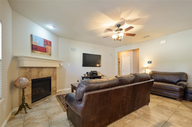 living room with ceiling fan and a fireplace