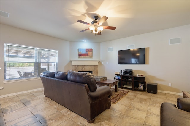 living room featuring light tile patterned floors, a tile fireplace, and ceiling fan