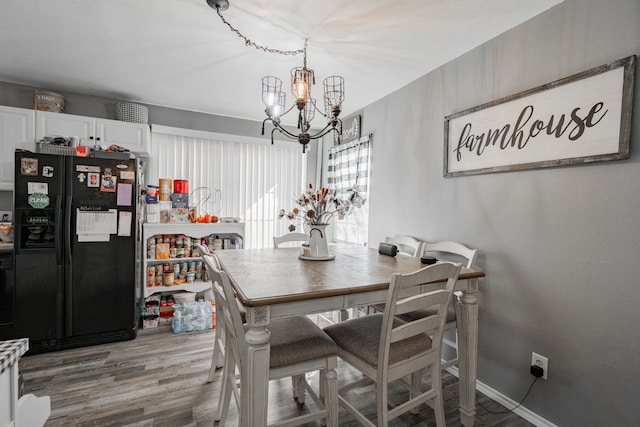 dining area featuring hardwood / wood-style flooring and a chandelier