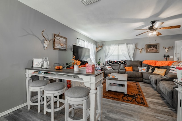 living room featuring ceiling fan and hardwood / wood-style flooring