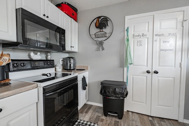 kitchen with black appliances, white cabinets, and dark hardwood / wood-style flooring