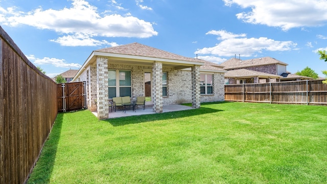 back of house with a patio area and a lawn