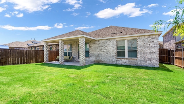 back of house with a yard and a patio