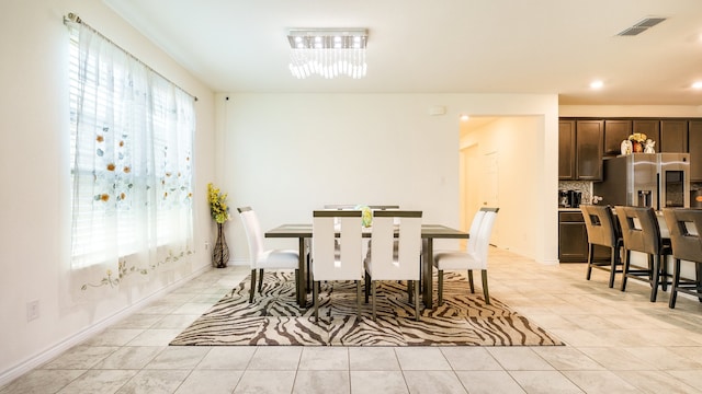 tiled dining room featuring an inviting chandelier