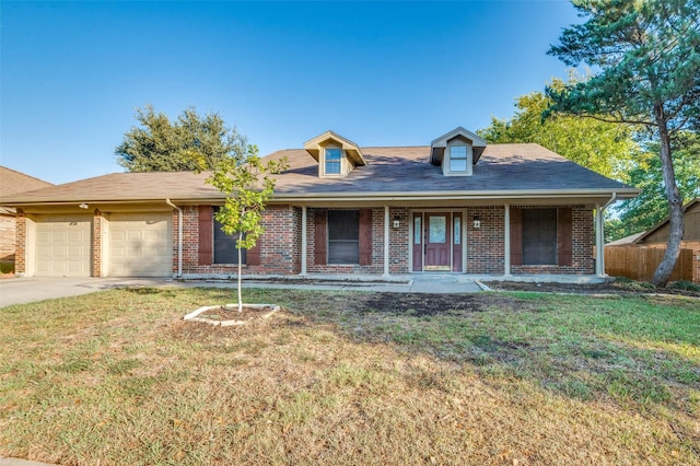 view of front of property featuring a garage, a front lawn, and a porch