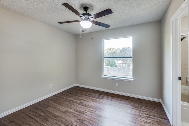 empty room featuring dark hardwood / wood-style flooring, ceiling fan, and a textured ceiling