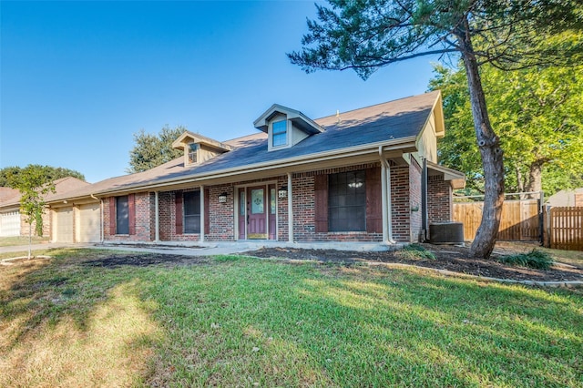 view of front facade featuring a garage, a front yard, and central air condition unit