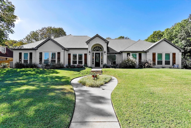 ranch-style house with a front yard and stucco siding