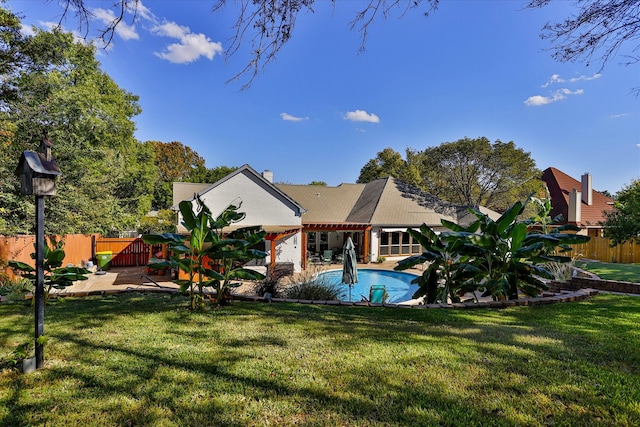 back of house with a yard, a patio area, and a fenced in pool