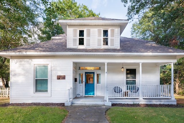 view of front facade with a front yard and covered porch