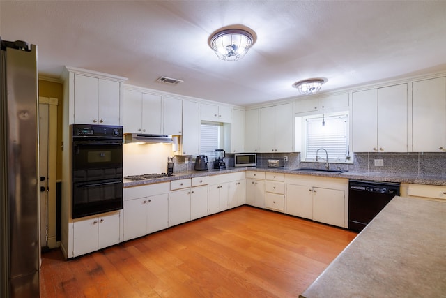 kitchen with sink, white cabinetry, light hardwood / wood-style flooring, and black appliances