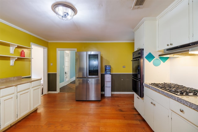 kitchen featuring crown molding, appliances with stainless steel finishes, hardwood / wood-style flooring, and white cabinets