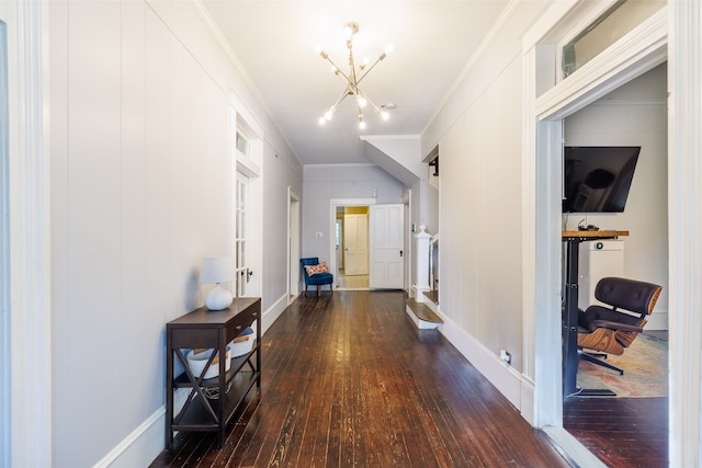 hallway with crown molding, dark hardwood / wood-style floors, and an inviting chandelier