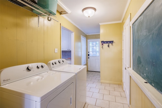 laundry room featuring crown molding, light tile patterned flooring, and washing machine and dryer