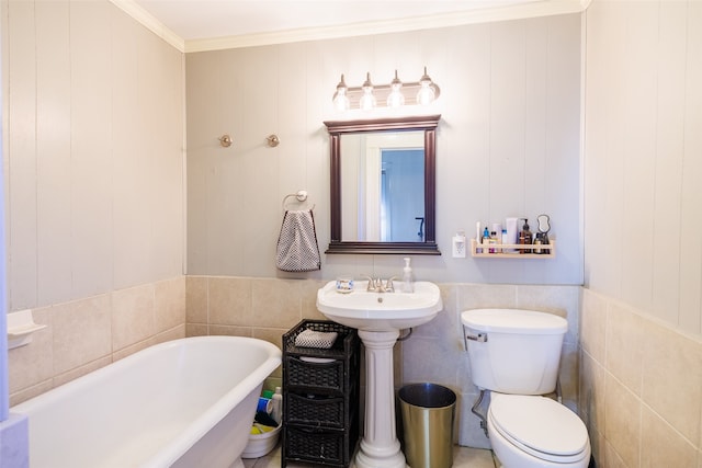 bathroom featuring toilet, tile walls, ornamental molding, and a bathtub