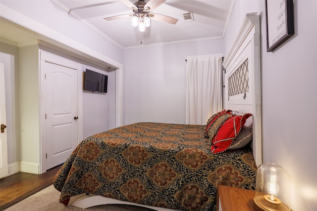 bedroom featuring ceiling fan, ornamental molding, and hardwood / wood-style floors