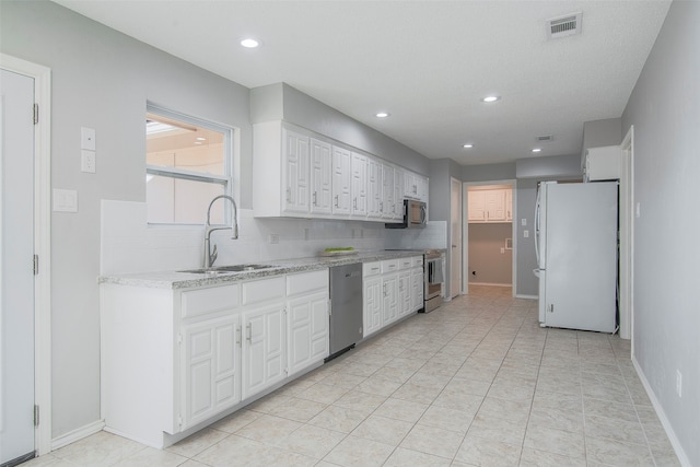 kitchen featuring light tile patterned floors, stainless steel appliances, sink, and white cabinets