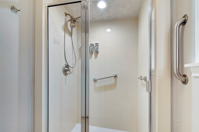 bathroom with a shower with door