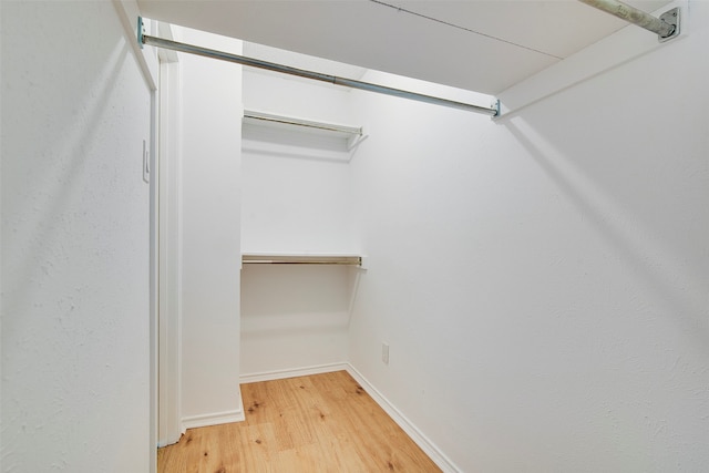 walk in closet with hardwood / wood-style flooring