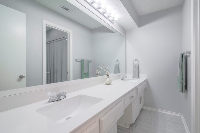 bathroom featuring vanity, a textured ceiling, and hardwood / wood-style flooring