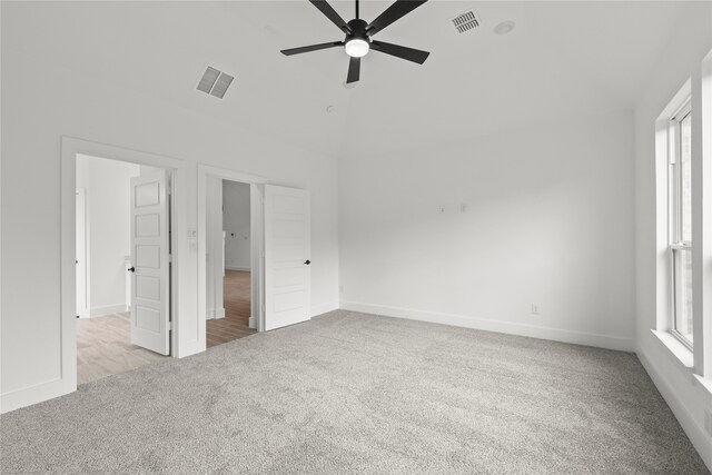 unfurnished bedroom with light carpet, vaulted ceiling, and ceiling fan